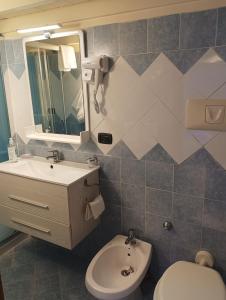 La salle de bains est pourvue d'un lavabo, de toilettes et d'un miroir. dans l'établissement B&B Maryflower, à Naples