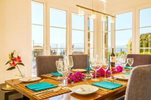 una mesa de comedor con gafas y servilletas azules en Casa Pura - Luxuriöses Ferienhaus mit Meerblick, en Llucmajor