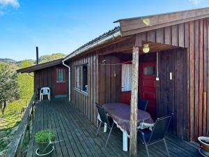 Helle的住宿－5 person holiday home in FARSUND，小屋在甲板上配有桌椅