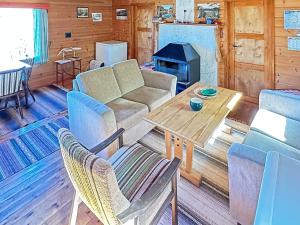 uma sala de estar com um sofá, uma mesa e um fogão em Two-Bedroom Holiday home in Farsund 4 em Helle