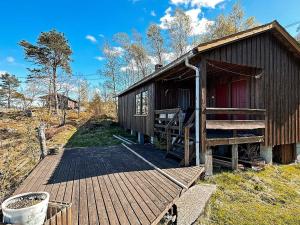 een hut met een houten terras ernaast bij Two-Bedroom Holiday home in Farsund 4 in Helle