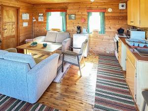 een woonkamer met een bank en een tafel bij Two-Bedroom Holiday home in Farsund 4 in Helle