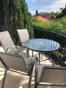 a patio with chairs and a glass table and chairs at Maja apartmanhàz in Balatonlelle