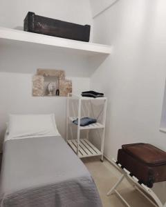 - une petite chambre avec un lit et une valise dans l'établissement Casa Garibaldi 246 Ostuni centro storico, à Ostuni