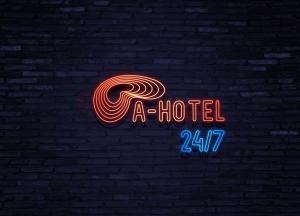 a neon sign that says a hotel in a brick wall at Campus Community A-Hotel in Kyiv