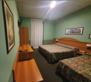 een hotelkamer met 2 bedden en groene muren bij Hotel Azalea in Baveno