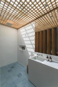 ein Badezimmer mit einer Badewanne, einem Waschbecken und einem Spiegel in der Unterkunft makali Temple Village in Canggu