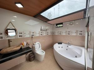 a bathroom with a tub and a toilet and a sink at Trốn Homestay, Cao Bằng in Cao Bằng