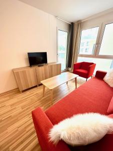 salon z czerwoną kanapą i telewizorem w obiekcie FORSTHAUS 30 FREE GARAGE w Wiedniu