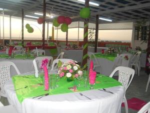 a table with a green table cloth and flowers on it at Tropical Court Hotel in Montego Bay