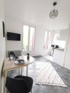 a white room with a table and a kitchen at Le Calme - Appartement 2 pièces in Alfortville