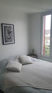 a bedroom with a bed with two pillows and a window at Le Calme - Appartement 2 pièces in Alfortville