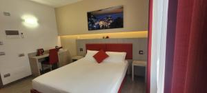 a bedroom with a white bed with a red headboard at Eden Rooms in La Spezia
