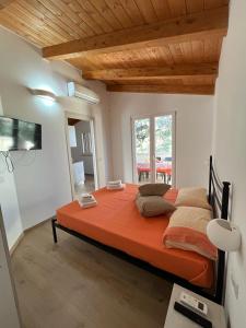 a bedroom with a large bed with orange sheets and pillows at Case vacanze la Quercia in Marina di Camerota