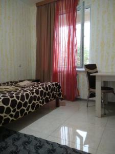 een slaapkamer met een bed, een tafel en een raam bij Natalia in Kobuleti