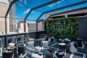a rooftop patio with tables and chairs and a green wall at Mayfair Hotel in Adelaide