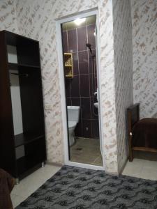 e bagno con servizi igienici e doccia con specchio. di Natalia - Bagrationi St # 42 a Kobuleti