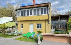 ein gelbes Haus mit blauen Stühlen davor in der Unterkunft Gorgeous Home In Viskovo With Kitchen in Viskovo