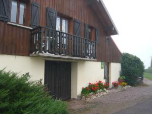 a building with a balcony and flowers in front of it at Gîte Champdray, 3 pièces, 4 personnes - FR-1-589-64 in Champdray