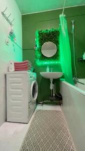 uma casa de banho verde com um lavatório e um chuveiro em 3 кімнатна затишна та комфортна квартира em Chernivtsi