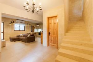 Una sala de estar con una escalera y un sofá. en Naduri, Beautiful Gozitan Villa plus Pool - Happy Rentals, en Nadur