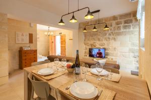 a dining room with a table with wine glasses at Naduri, Beautiful Gozitan Villa plus Pool - Happy Rentals in Nadur