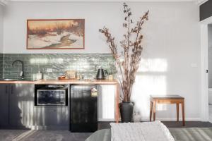 een keuken met een zwarte koelkast en een aanrecht bij 16 Scenic by Regional Escapes in Geelong