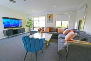 林伍德的住宿－Maroondah 3BR Brick Entire Home Free Wi-Fi Parking，客厅配有沙发和桌子