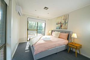 een slaapkamer met een bed en een raam bij Maroondah 3BR Brick Entire Home Free Wi-Fi Parking in Ringwood