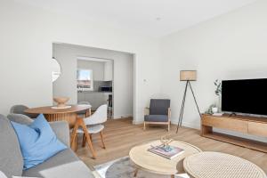 a living room with a couch and a tv at Urban Rest Neutral Bay Apartments in Sydney