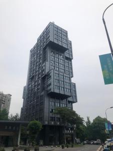 un edificio alto con muchas ventanas en una calle en He&Her Youth Hostel en Hangzhou