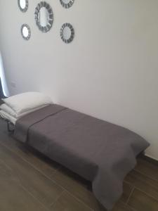 a bed in a room with clocks on the wall at Sandstone A8 Marsascala - 15minute drive to Valletta in Marsaskala