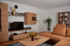 sala de estar con sofá y TV en Ferienwohnungen am Schambacher Weg, en Riedenburg