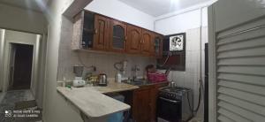 a small kitchen with wooden cabinets and a stove at شقة فندقية علي البحر مباشرة بجليم in Alexandria +37 photos