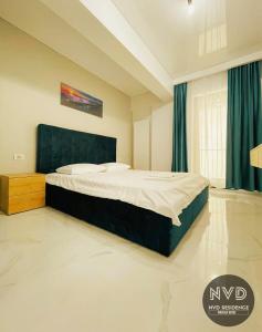 a bedroom with a large bed with blue curtains at NVD Residence Mamaia-NORD in Mamaia Sat/Năvodari