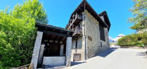 um edifício com uma varanda ao lado de uma estrada em La Maison de l'oncle- Bluchalet em La Salle