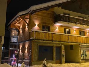un edificio con balcone e orologio di Room4You a Oulx
