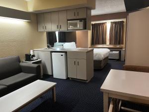 um pequeno quarto de hotel com uma cama e um sofá em Microtel Inn & Suites by Wyndham Houston/Webster/Nasa/Clearlake em Nassau Bay