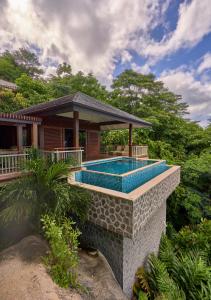 a house with a swimming pool in front of a house at Villa Salazie in Mahe