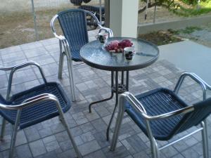 a table and chairs with a bowl of fruit on a patio at Cosmitsa House in Vingláfia