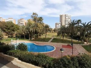 une piscine dans un parc avec des palmiers et des bâtiments dans l'établissement Raspeig, El Campello, à El Campello