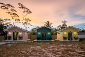 2 maisons en face d'un coucher de soleil dans l'établissement The Byan House Villa In Belitung, à Tanjung Pandan