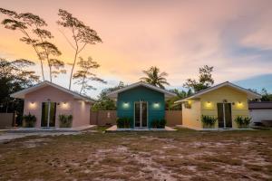 two houses in front of a sunset at The Byan House Villa In Belitung in Tanjungpandan