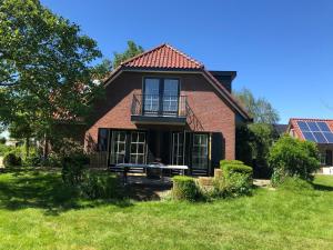 une maison en briques rouges avec un banc dans la cour dans l'établissement Lovely warm Country home, à Breukeleveen