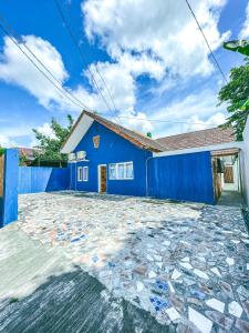 ein blaues Haus mit steinerner Einfahrt in der Unterkunft OsOs Paviliun in Timuran