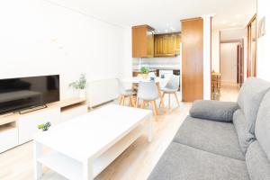 een woonkamer met een bank en een tafel bij Apartamento Cimadevilla II in Gijón