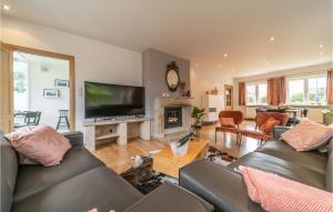 ein Wohnzimmer mit 2 Sofas und einem TV in der Unterkunft Beautiful Home In Oostduinkerke With Kitchen in Oostduinkerke