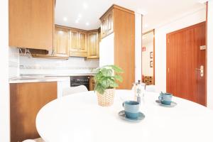 een keuken met een tafel met een plant erop bij Apartamento Cimadevilla II in Gijón