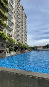 a large blue swimming pool next to a tall building at B Landmark Residence in Bandung