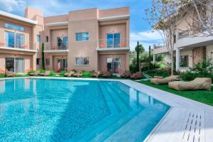 a villa with a swimming pool in front of a house at Saronis Suites in Saronida +72 photos